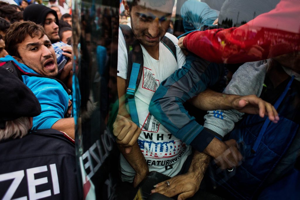 Migrants struggle to enter a bus which takes them further into Austria at the Hungarian-Austrian border in Nickelsdorf, eastern Austria. Migrants struggle to enter a bus which takes them further into Austria at the Hungarian-Austrian border in Nickelsdorf, eastern Austria.