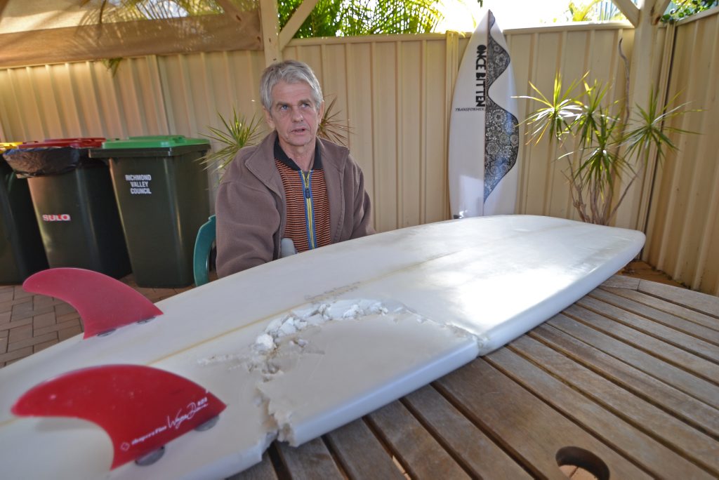 ONCE BITTEN: Evans Head resident Craig Ison with the board he was riding when he was attacked by a great white shark at Main Beach. In the background is the new board made for him by his good friend Darin Reilly. ONCE BITTEN: Evans Head resident Craig Ison with the board he was riding when he was attacked by a great white shark at Main Beach. In the background is the new board made for him by his good friend Darin Reilly.