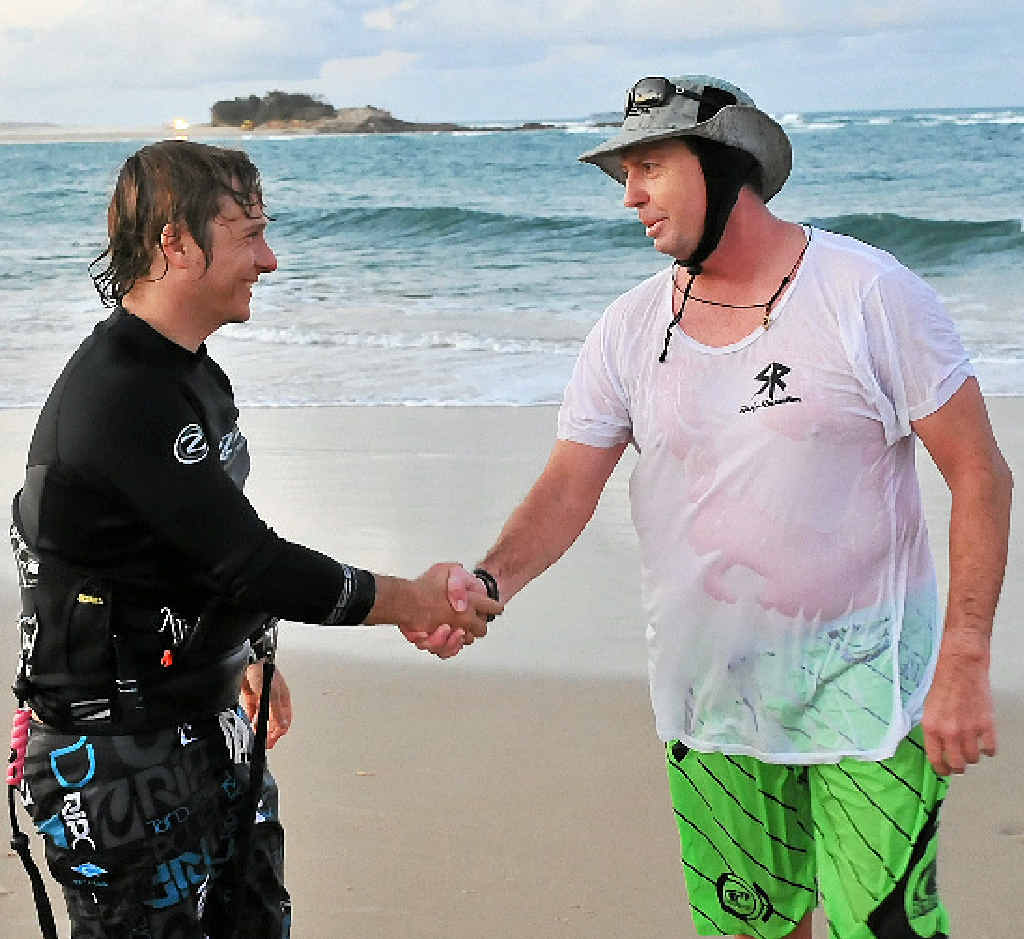 THANKS, MATE: The rescued man, left, who only wanted to be known as a local kiteboarder, shakes the hand of paddleboarder Grant Lundgren. THANKS, MATE: The rescued man, left, who only wanted to be known as a local kiteboarder, shakes the hand of paddleboarder Grant Lundgren.