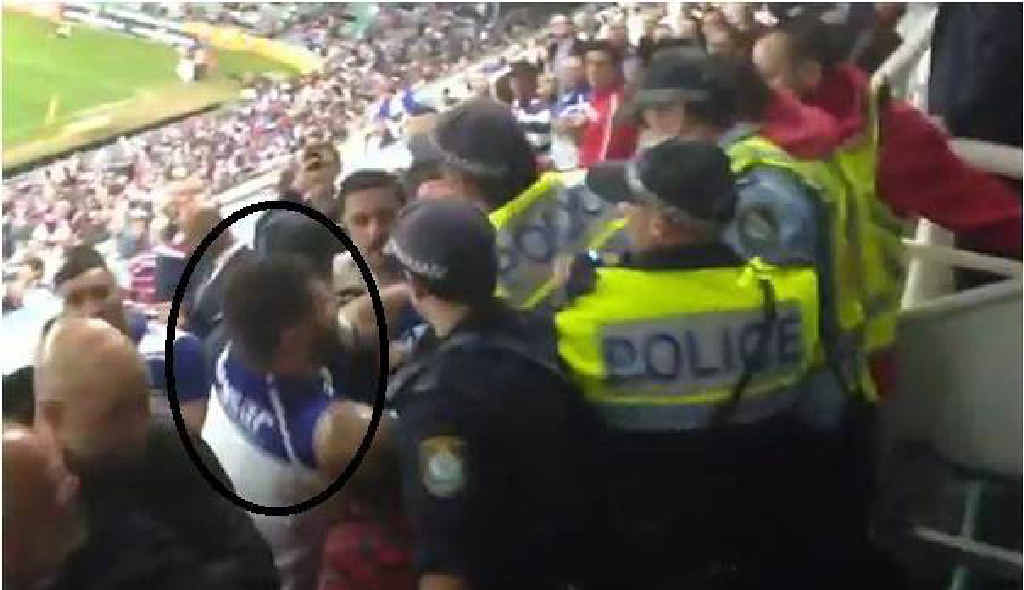 BAD FORM: A Bulldogs fan ‘throws a punch’ at a policeman as fans clash with officers after their NRL loss to the Sydney Roosters. BAD FORM: A Bulldogs fan ‘throws a punch’ at a policeman as fans clash with officers after their NRL loss to the Sydney Roosters.