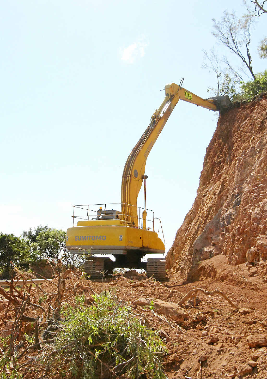 A large excavator works to clear loose rock and earth from the cliff adjacent to the Scenic Hwy near Statue Bay after Cyclone Marcia. A large excavator works to clear loose rock and earth from the cliff adjacent to the Scenic Hwy near Statue Bay after Cyclone Marcia.