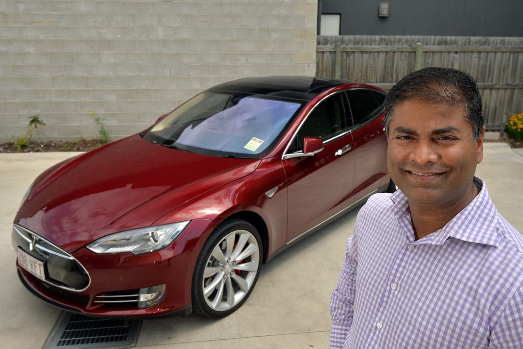 Vasantha Kumar Srinivasan with his red Tesla. Vasantha Kumar Srinivasan with his red Tesla.