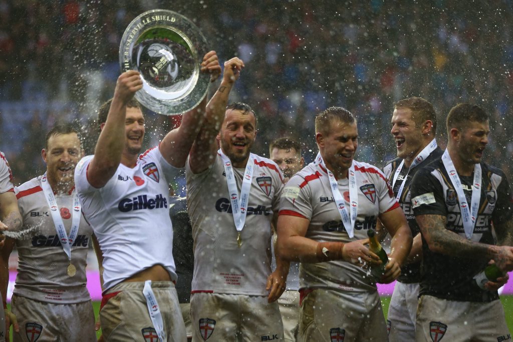 Sean O'Loughlin the captain of England lifts the winners trophy alongside Josh Hodgson (C) and Mike Cooper (2R) after clinching the series 2-1 over New Zealand at DW Stadium in Wigan. Photo: Michael Steele/Getty Images. Sean O'Loughlin the captain of England lifts the winners trophy alongside Josh Hodgson (C) and Mike Cooper (2R) after clinching the series 2-1 over New Zealand at DW Stadium in Wigan. Photo: Michael Steele/Getty Images.