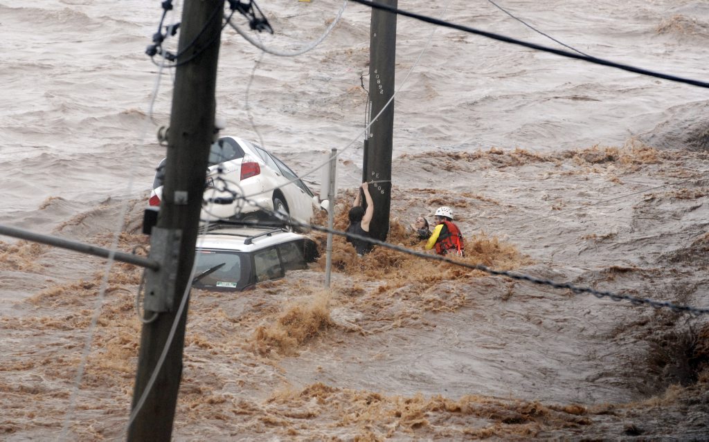 Flash flooding in Dent St. Hannah Reardon-Smith and her mother Kathryn struggling against floodwaters as an emergency services worker battled to rescue them. Photo Nev Madsen / The Chronicle Flash flooding in Dent St. Hannah Reardon-Smith and her mother Kathryn struggling against floodwaters as an emergency services worker battled to rescue them. Photo Nev Madsen / The Chronicle