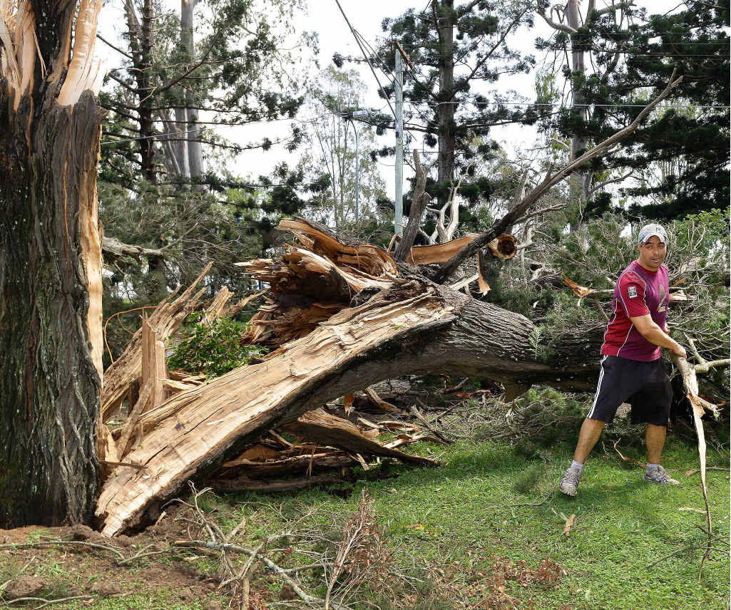 A resident helps the clean-up on Brisbane Terrace in Goodna on Monday morning. A resident helps the clean-up on Brisbane Terrace in Goodna on Monday morning.