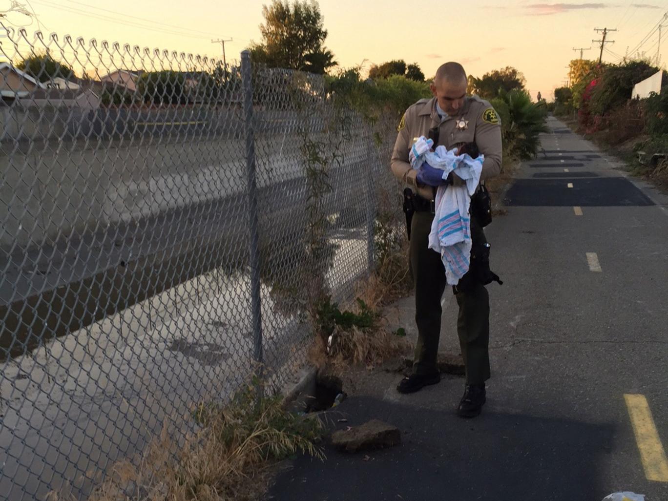 Two officers removed the pieces of asphalt and debris off the baby Los Angeles County Sheriff's Department Two officers removed the pieces of asphalt and debris off the baby Los Angeles County Sheriff's Department
