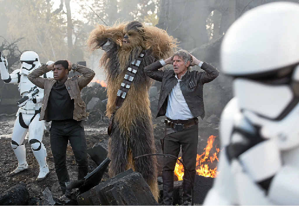 John Boyega, Peter Mayhew (as Chewbacca) and Harrison Ford in a scene from the movie Star Wars: The Force Awakens. John Boyega, Peter Mayhew (as Chewbacca) and Harrison Ford in a scene from the movie Star Wars: The Force Awakens.