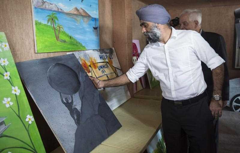 Defence Minister Harjit Sajjan, buys a painting from a refugee artist while touring the Zaatari Refugee Camp, near the city of Mafraq, Jordan, on Sunday, Nov. 29, 2015. Defence Minister Harjit Sajjan, buys a painting from a refugee artist while touring the Zaatari Refugee Camp, near the city of Mafraq, Jordan, on Sunday, Nov. 29, 2015.