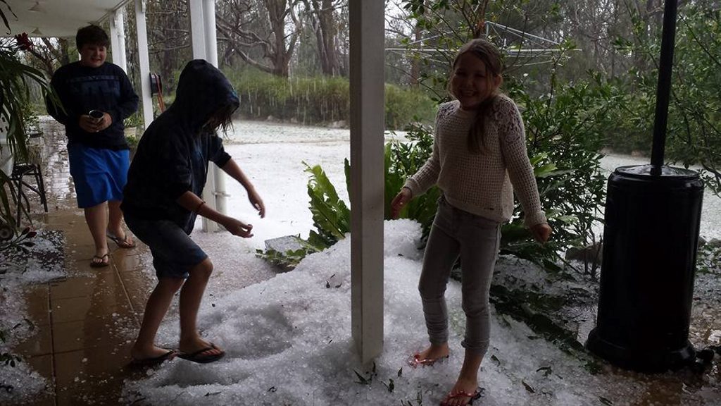 Stanthorpe residents are all smiles as they play in the hail caused by yesterday's storms. Stanthorpe residents are all smiles as they play in the hail caused by yesterday's storms.