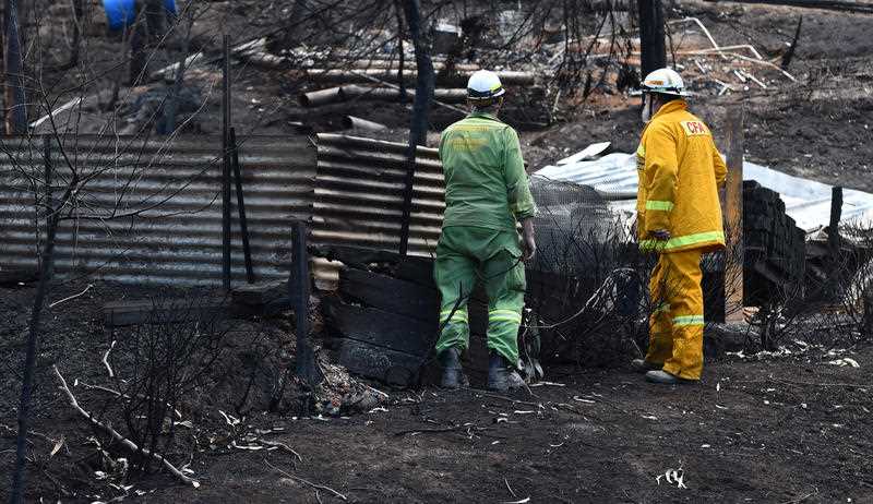 Emergency services workers inspect fire damaged buildings at Separation Creek in the Otway Ranges south of Melbourne, Sunday, Dec. 27, 2015. Emergency services workers inspect fire damaged buildings at Separation Creek in the Otway Ranges south of Melbourne, Sunday, Dec. 27, 2015.