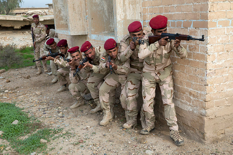 Iraqi Army soldiers duck below windows as they stack up on a wall before clearing a building during training. Photo: ADF Iraqi Army soldiers duck below windows as they stack up on a wall before clearing a building during training. Photo: ADF