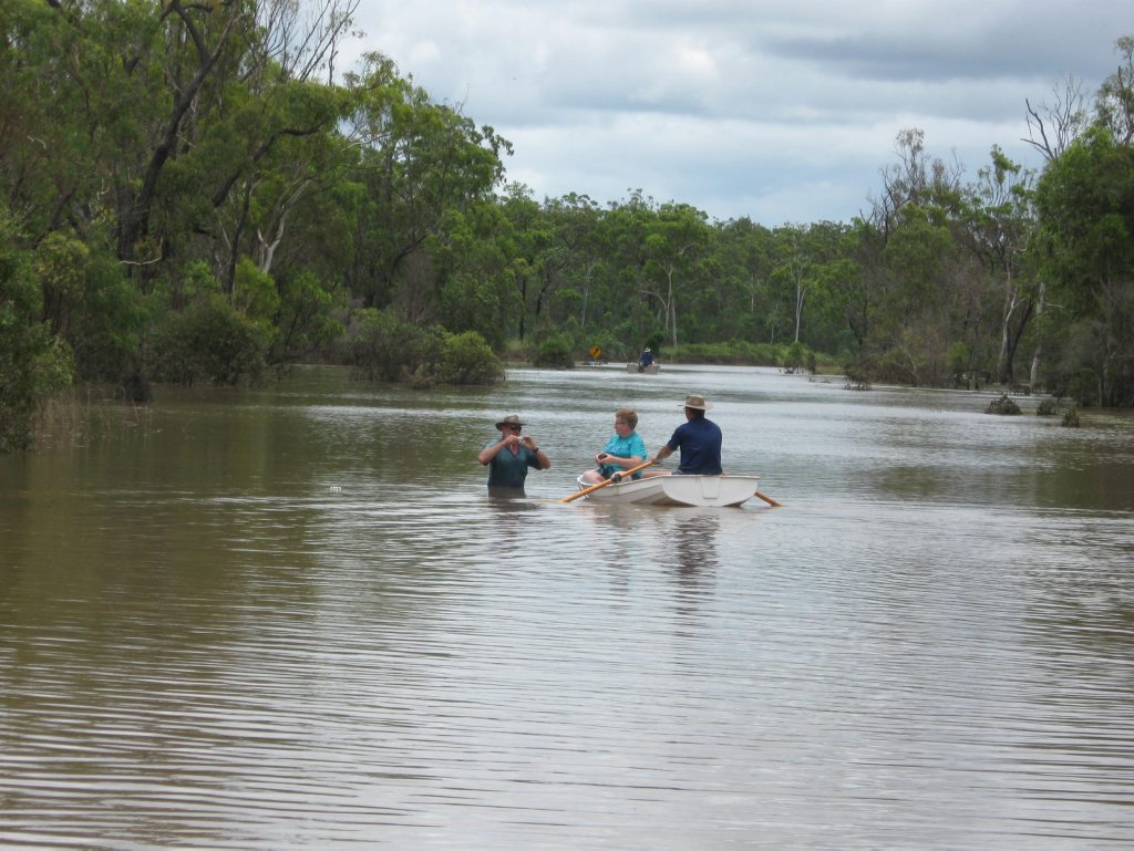 WATERWAY:  Frank McKee, in the water, of the southern end of Monto Road meets Albert and Judy Spencer (in boat) from the northern end of the road when the valley was cut off in 2010.