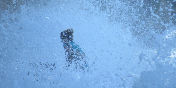 The waves have now engulfed the woman and her pram. Photo / Eliane Souza The waves have now engulfed the woman and her pram. Photo / Eliane Souza