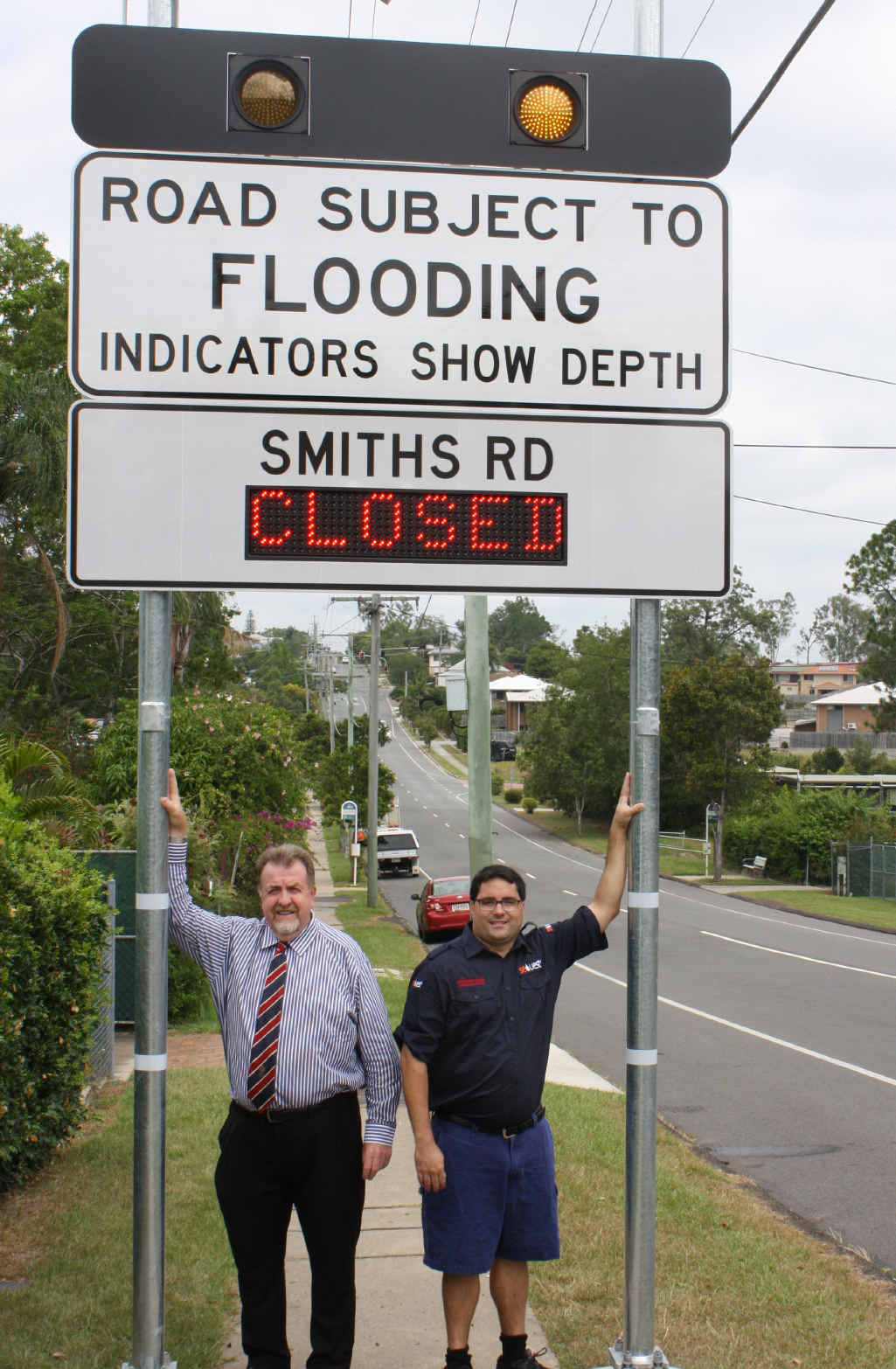 EARLY WARNING: Goodna Councillor Paul Tully (left) launches the new flood signs at Goodna with Shane Barnes from SEQ UHF Emergency Services Team. (LEFT) Flooding on Albert St in 2014. EARLY WARNING: Goodna Councillor Paul Tully (left) launches the new flood signs at Goodna with Shane Barnes from SEQ UHF Emergency Services Team. (LEFT) Flooding on Albert St in 2014.