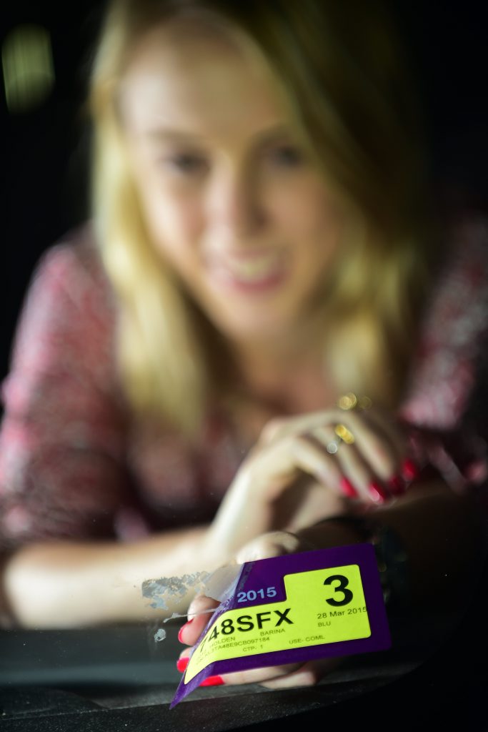 *WARNING - DARK IMAGES PLEASE NOT TO GO THROUGH COLOURFACTORY* Leilani Waters peels off her rego sticker as October 1 sees new legislation meaning they are no longer required on the windscreen. Photo: Iain Curry / Sunshine Coast Daily *WARNING - DARK IMAGES PLEASE NOT TO GO THROUGH COLOURFACTORY* Leilani Waters peels off her rego sticker as October 1 sees new legislation meaning they are no longer required on the windscreen. Photo: Iain Curry / Sunshine Coast Daily
