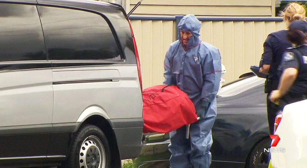 Police and forensic officers inspect a Booval property where a man was fatally shot. The undertaker removes the body from the scene. Photo: Contributed / Seven News Police and forensic officers inspect a Booval property where a man was fatally shot. The undertaker removes the body from the scene. Photo: Contributed / Seven News