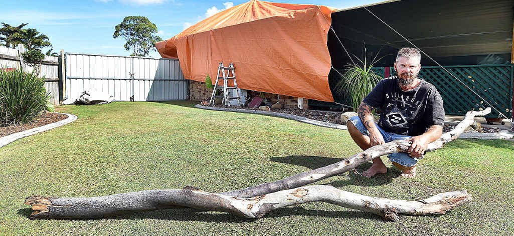 STORM DAMAGE: Eli Waters resident Troy Mitchell with the branch that speared through his patio sliding door from a gum tree in the park behind his house. STORM DAMAGE: Eli Waters resident Troy Mitchell with the branch that speared through his patio sliding door from a gum tree in the park behind his house.