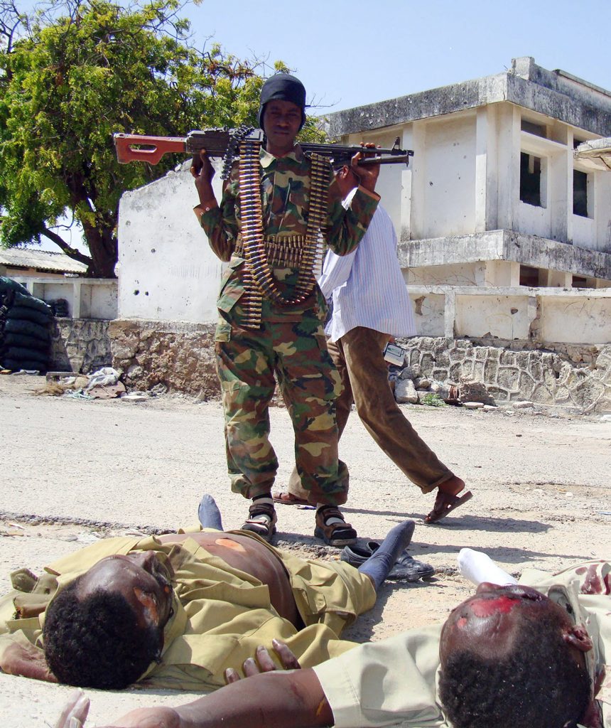 An Al-Shabaab fighter views the bodies of two dead government soldiers, in the north of Mogadishu Monday, July, 13, 2009. Islamic insurgents have retreated from areas around Somalia's presidential palace after a day of fighting that killed dozens of people and wounded about 150, witnesses said Monday. Sunday's fighting marked the first time African Union peacekeepers directly intervened to support government forces, Somali military spokesman Farhan Asanyo said the government made a strategic retreat. (AP Photo/Mohamed Sheikh Nor) An Al-Shabaab fighter views the bodies of two dead government soldiers, in the north of Mogadishu Monday, July, 13, 2009. Islamic insurgents have retreated from areas around Somalia's presidential palace after a day of fighting that killed dozens of people and wounded about 150, witnesses said Monday. Sunday's fighting marked the first time African Union peacekeepers directly intervened to support government forces, Somali military spokesman Farhan Asanyo said the government made a strategic retreat. (AP Photo/Mohamed Sheikh Nor)