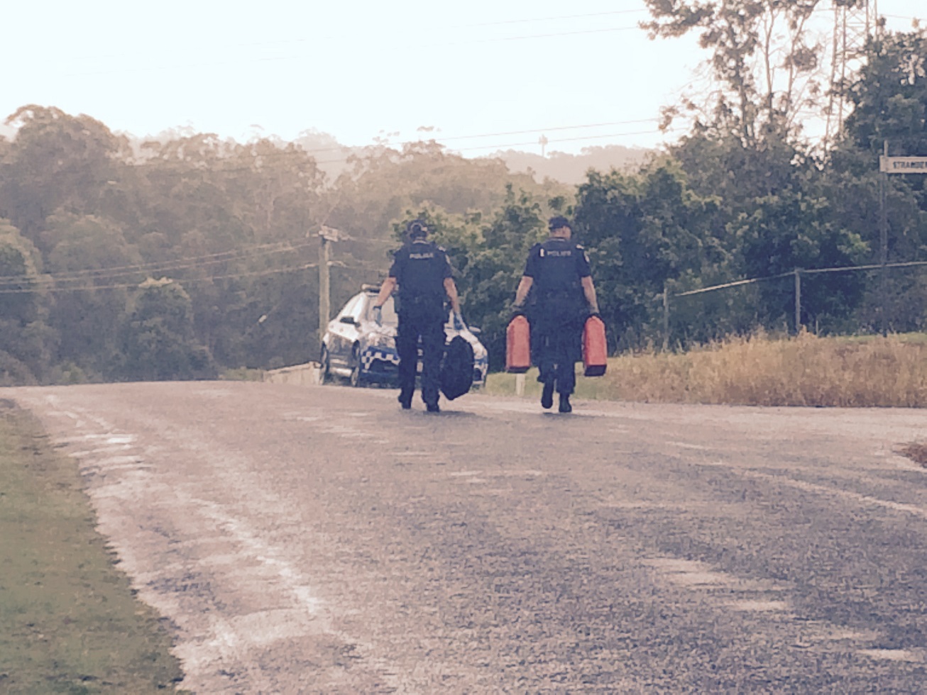 Police with fuel canisters seized from a Beerwah home. Police with fuel canisters seized from a Beerwah home.