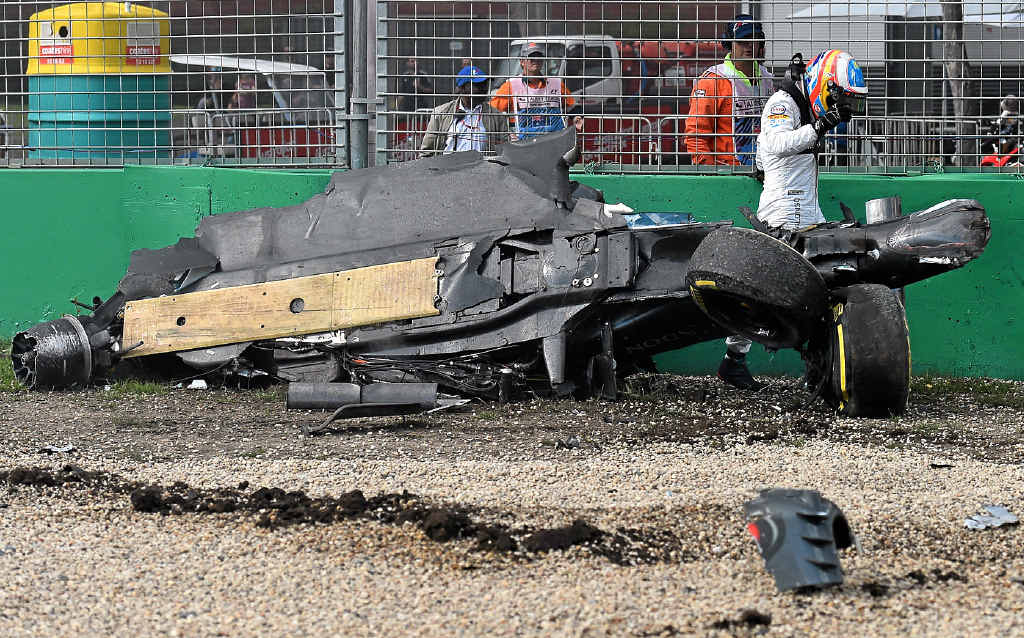 AFTERMATH: McLaren driver Fernando Alonso walks away from a crash. AFTERMATH: McLaren driver Fernando Alonso walks away from a crash.