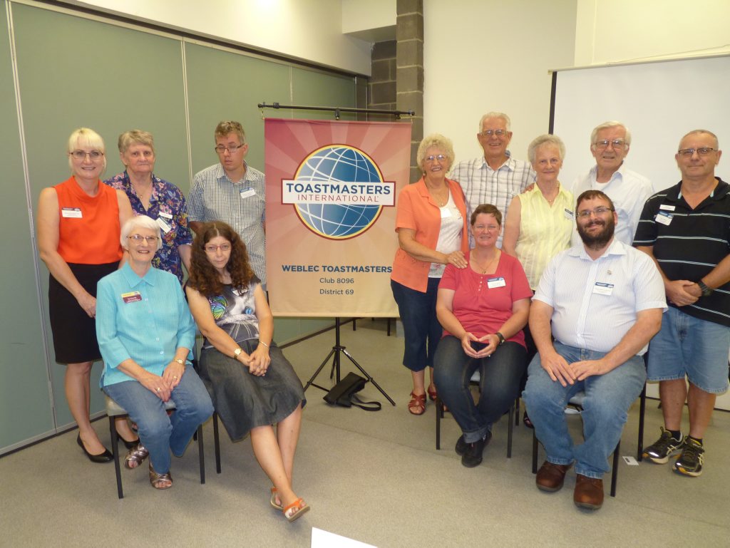 Members of the Weblec Club surrounding their banner. For the first time banners will be displayed digitally at their district convention at the Gold Coast in May.