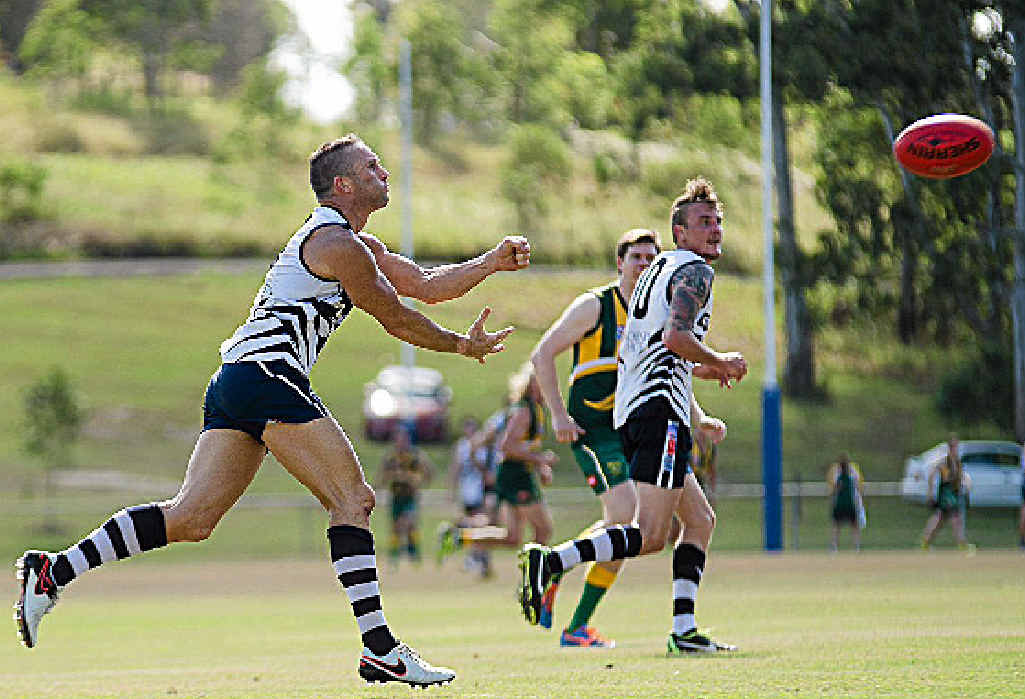 PASS: Cats player Brent Forsyth finds a team mate in a recent game.