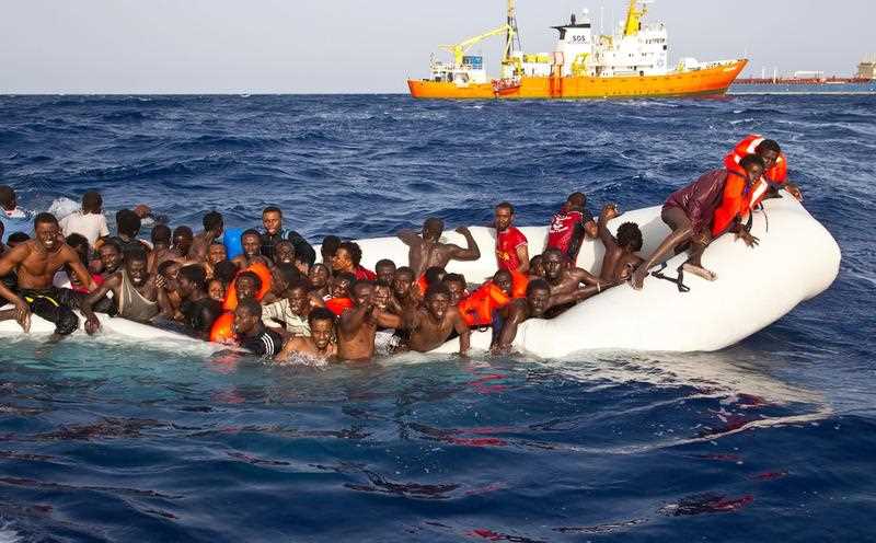 A handout photgraph made available by the Ong Sos Méditerranée showing migrants on a snking inflatable boat before being rescued by the Aquarius ship of the humanitarian group SOS Mediterranee, and taken to Lampesusa, Italy, 18 April 2016. A handout photgraph made available by the Ong Sos Méditerranée showing migrants on a snking inflatable boat before being rescued by the Aquarius ship of the humanitarian group SOS Mediterranee, and taken to Lampesusa, Italy, 18 April 2016.