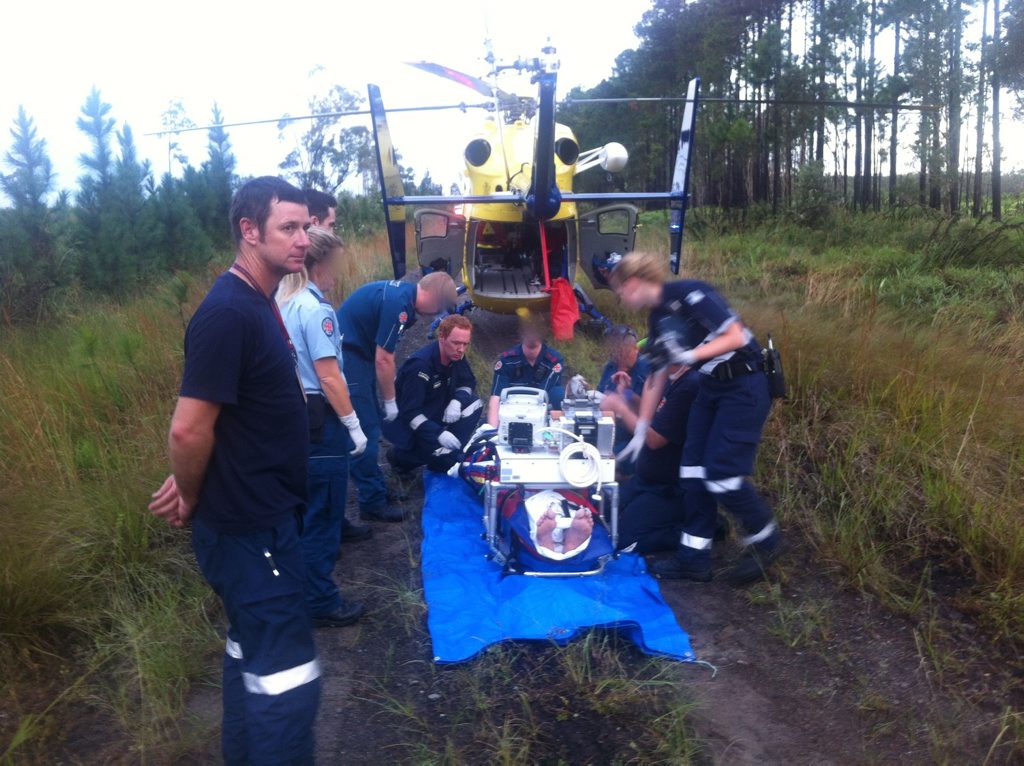 Paramedics treat a patient at Coochin Creek. Paramedics treat a patient at Coochin Creek.