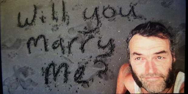 ohn McKeowen wrote his romantic proposal to Tracy Glover - inset, with son Keenan - in the sand while they were on holiday in Taranaki. Photo / Supplied ohn McKeowen wrote his romantic proposal to Tracy Glover - inset, with son Keenan - in the sand while they were on holiday in Taranaki. Photo / Supplied