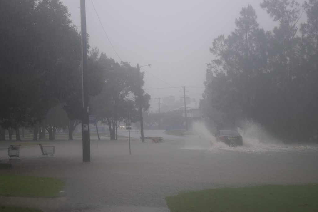 A car driving through floodwater on Brewster St near the Lismore shopping centre A car driving through floodwater on Brewster St near the Lismore shopping centre