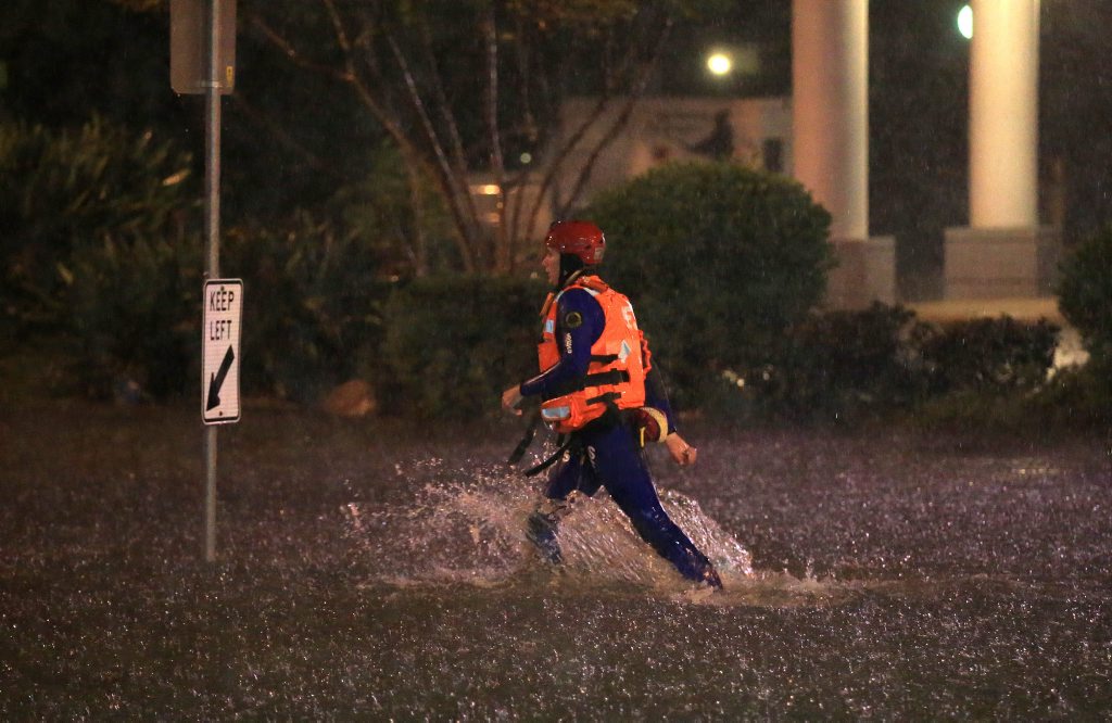 A SES Officer runs to the rescue of a broken down driver in flood water on Darlington Drive Banora Point. A SES Officer runs to the rescue of a broken down driver in flood water on Darlington Drive Banora Point.