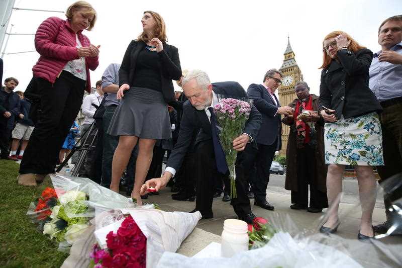 Labour Party leader Jeremy Corbyn, centre, lays a candle as he and deputy leader Tom Watson, centre rear, Thursday June 16, 2016, attend an impromptu vigil at Parliament Square opposite the Palace of Westminster, central London, following the death of Labour Member of Parliament, Jo Cox. Labour Party leader Jeremy Corbyn, centre, lays a candle as he and deputy leader Tom Watson, centre rear, Thursday June 16, 2016, attend an impromptu vigil at Parliament Square opposite the Palace of Westminster, central London, following the death of Labour Member of Parliament, Jo Cox.
