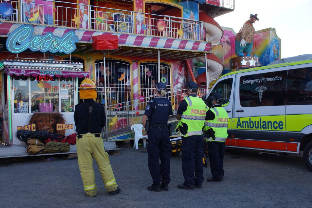 A female is wheeled out of the Magic Circus ride and into an ambulance at Mackay Show this afternoon after a reported injury.
