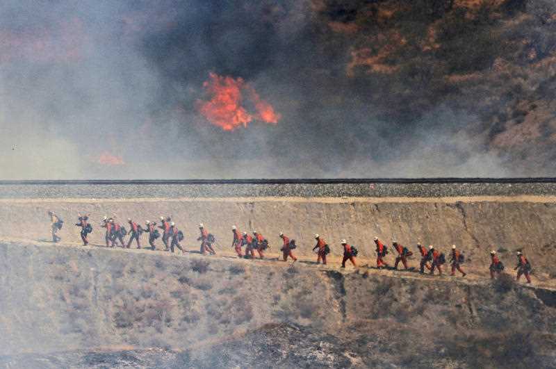 A fire crew approaches as a wildfire burns on Friday, July 22 A fire crew approaches as a wildfire burns on Friday, July 22