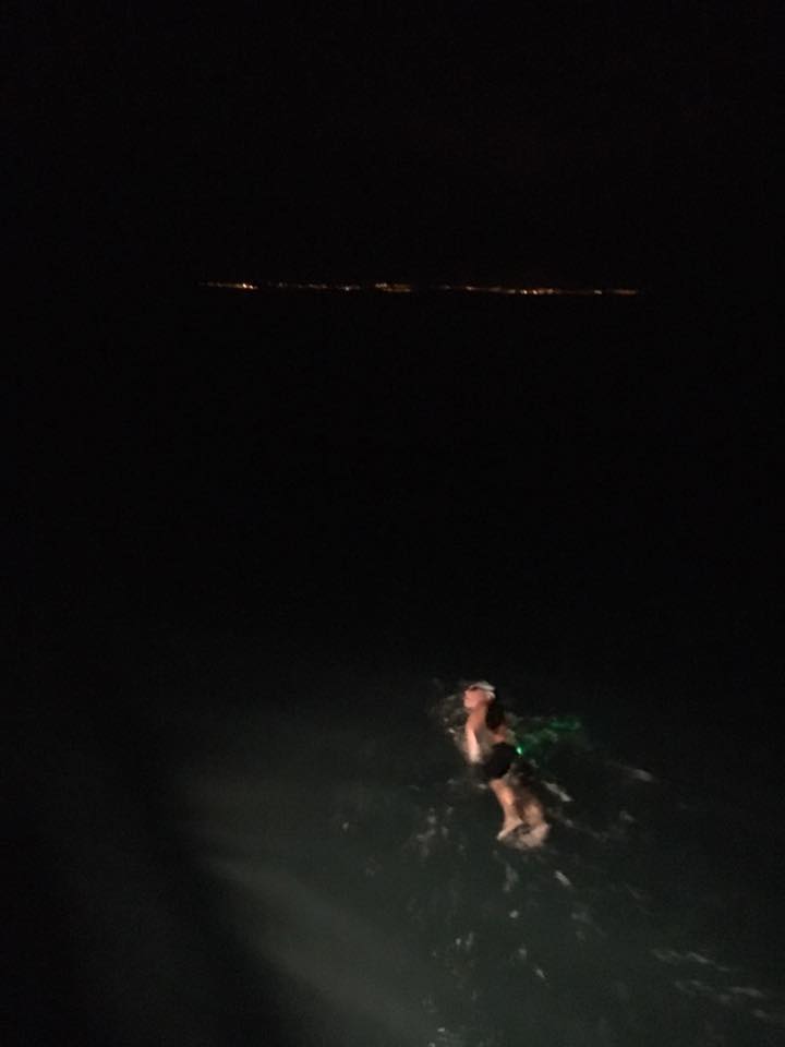 Chris Shapland is being guided by a spotlight from his support team and lights from the coastline of France. Chris Shapland is being guided by a spotlight from his support team and lights from the coastline of France.