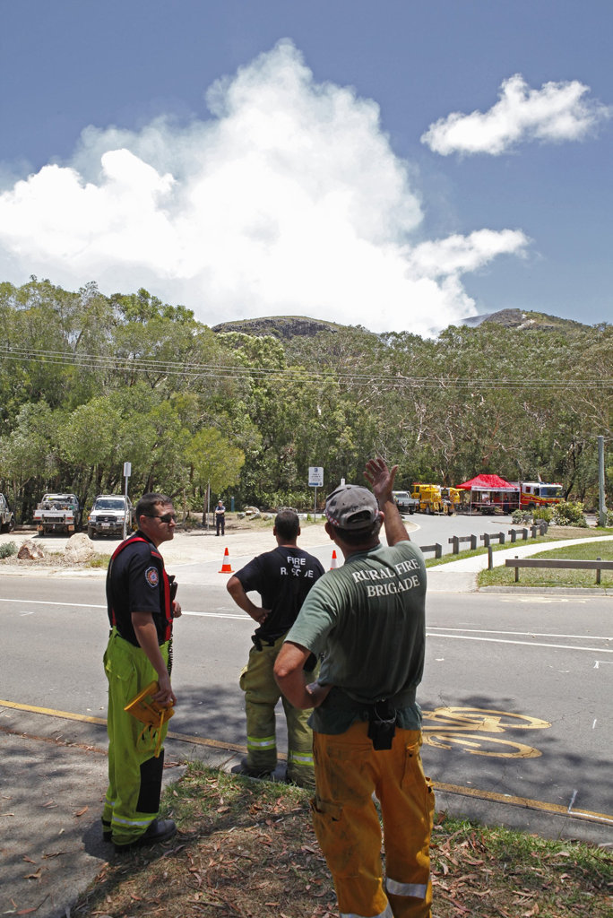 Firefighters watch on as smoke rises from a vegetation fire on Mount Coolum. Firefighters watch on as smoke rises from a vegetation fire on Mount Coolum.