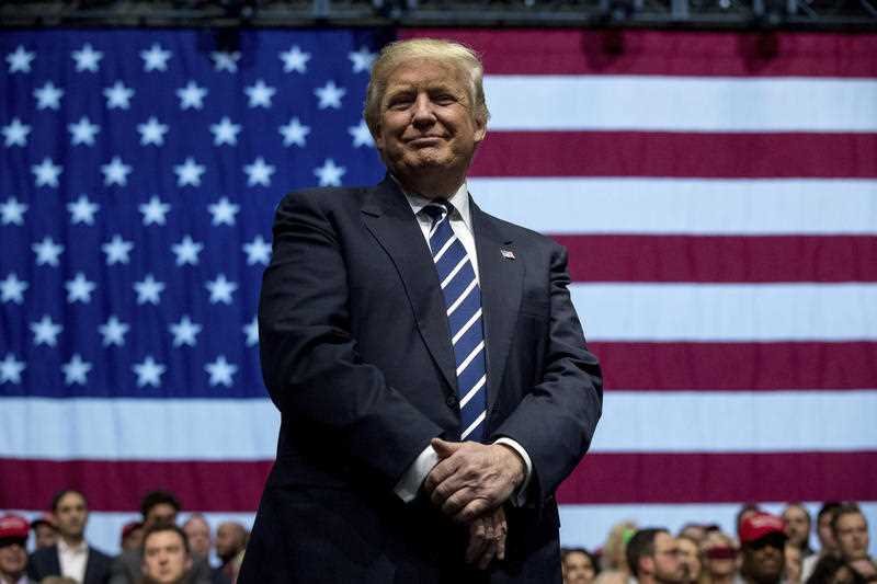President-elect Donald Trump smiles as he listens to his pick for Education Secretary Betsy DeVos speak during a rally at DeltaPlex Arena, Friday, Dec. 9, 2016, in Grand Rapids, Mich. President-elect Donald Trump smiles as he listens to his pick for Education Secretary Betsy DeVos speak during a rally at DeltaPlex Arena, Friday, Dec. 9, 2016, in Grand Rapids, Mich.