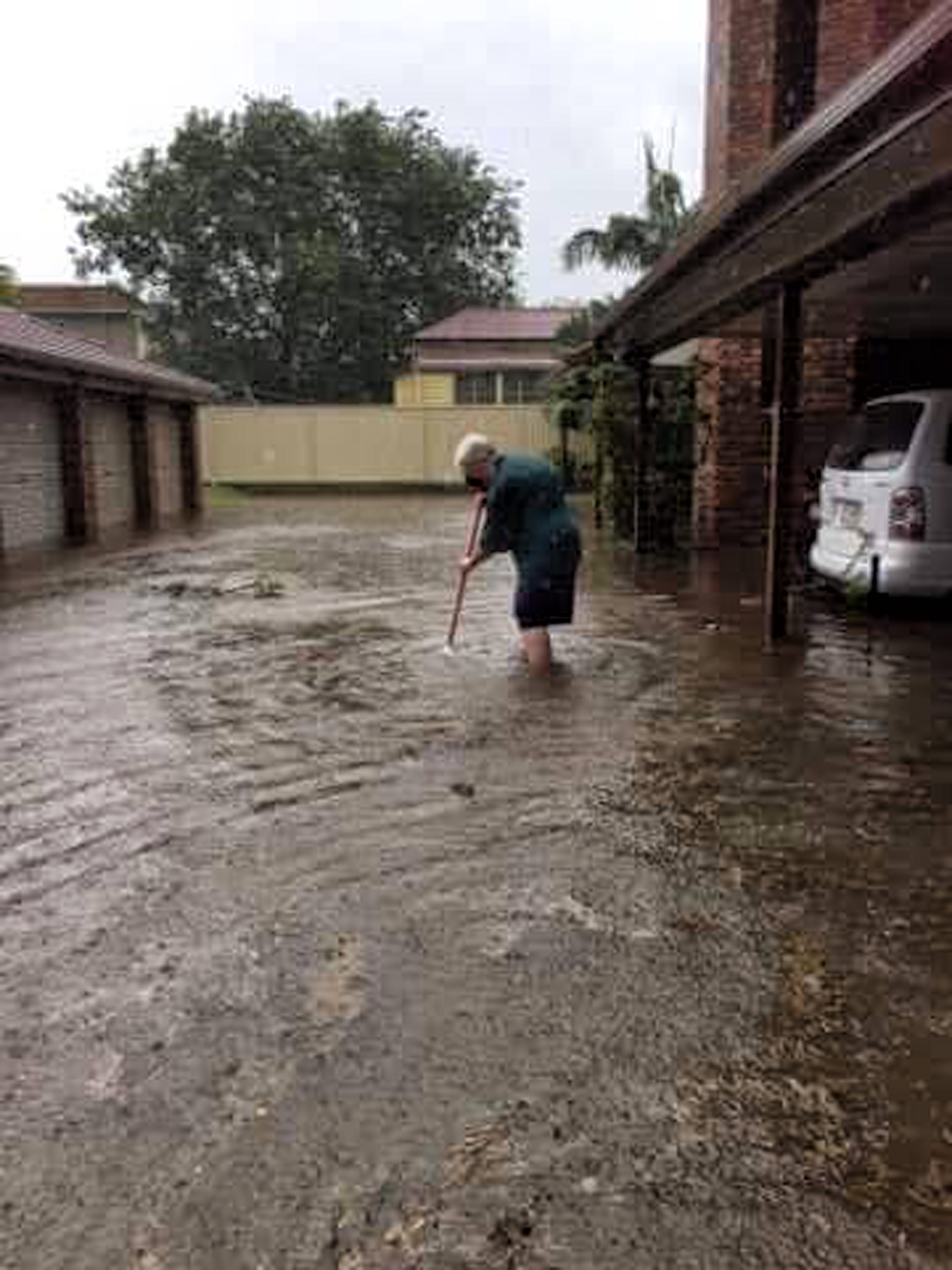 Colleen Mallet attempts to clean a blocked drain that caused flooding at her Booval home on Sunday Colleen Mallet attempts to clean a blocked drain that caused flooding at her Booval home on Sunday