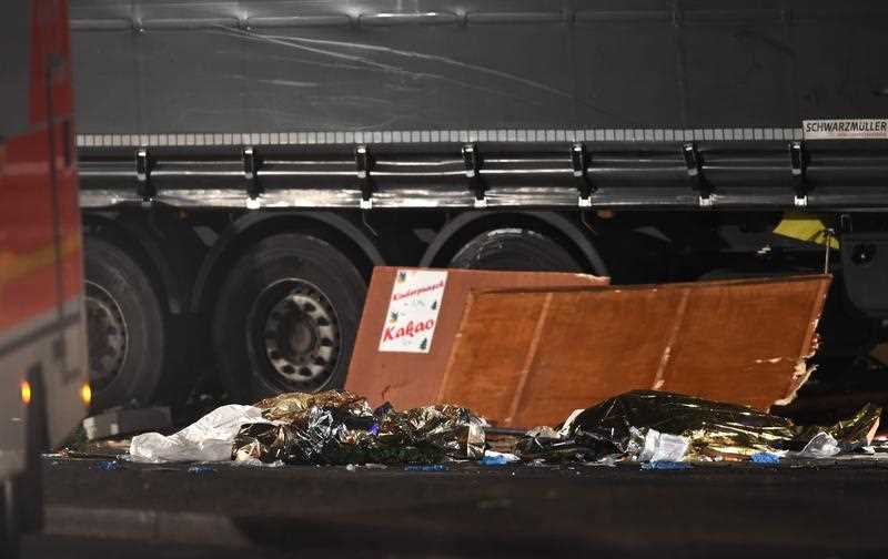 Damaged parts of a stalls lie against a truck at the scene after it crashed into a Christmas market, close to the Kaiser Wilhelm memorial church in Berlin