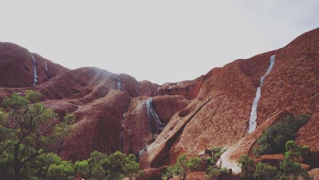 Waterfalls at Uluru as heavy rain across the Northern Territory forced the closure of the National Park. Picture: Instagram/dnjswl92 Waterfalls at Uluru as heavy rain across the Northern Territory forced the closure of the National Park. Picture: Instagram/dnjswl92