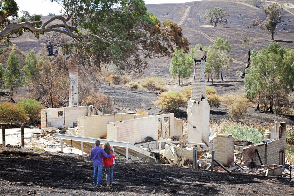 Scott Pape and his wife Liz pictured on their farm after a bushfire in 2014. Scott Pape and his wife Liz pictured on their farm after a bushfire in 2014.