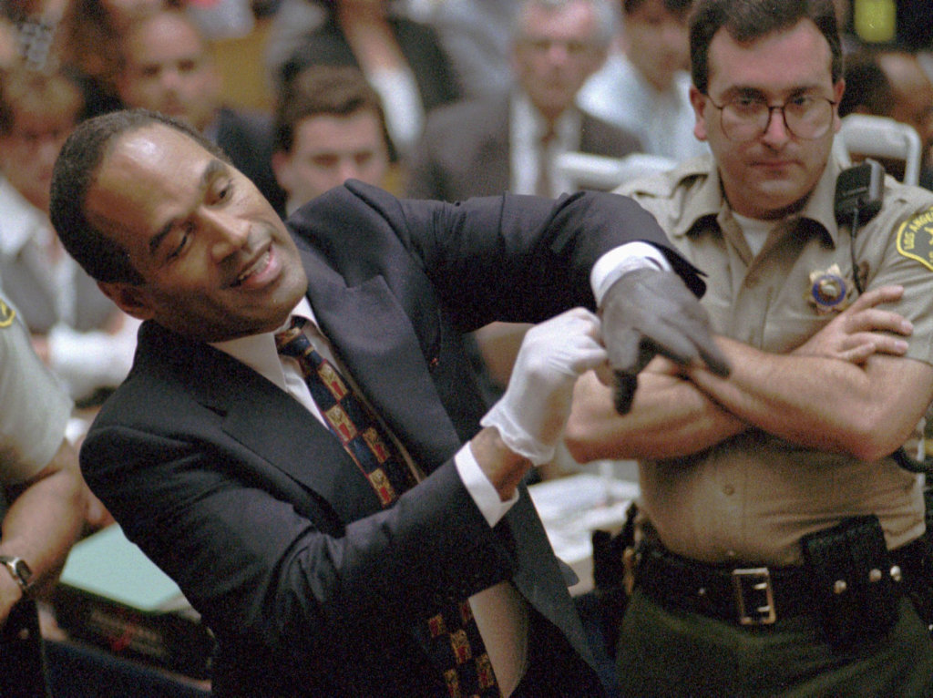 FILE - In this June 15, 1995, file photo, murder defendant, O.J. Simpson grimaces as he tries on one of the leather gloves prosecutors say he wore the night his ex-wife Nicole Brown Simpson and Ron Goldman were murdered, during the Simpson double-murder trial in Los Angeles. FILE - In this June 15, 1995, file photo, murder defendant, O.J. Simpson grimaces as he tries on one of the leather gloves prosecutors say he wore the night his ex-wife Nicole Brown Simpson and Ron Goldman were murdered, during the Simpson double-murder trial in Los Angeles.