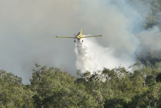 A fire bomber drops water on the blaze A fire bomber drops water on the blaze